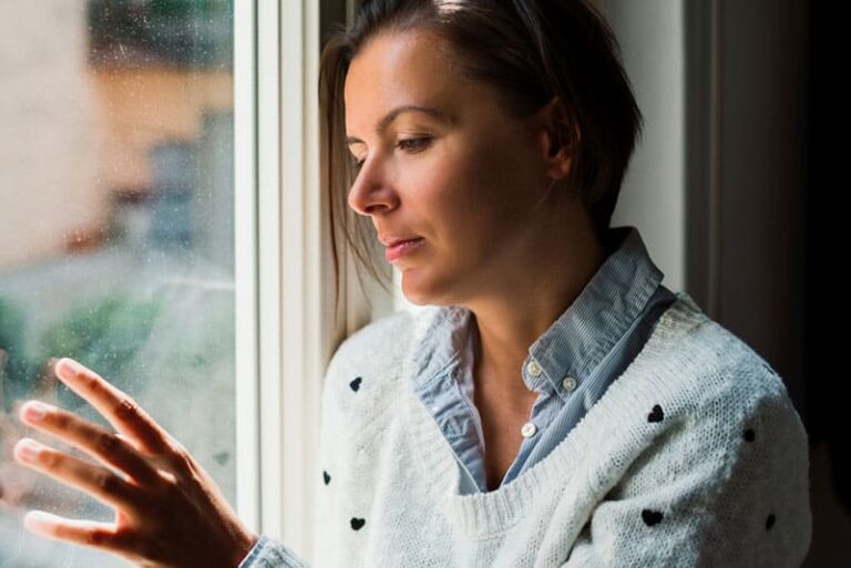 sad woman looking trough the window