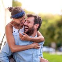 pareja sonriente y enamorada divirtiéndose al aire libre