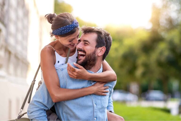 Coppia sorridente e innamorata che si diverte all'aperto