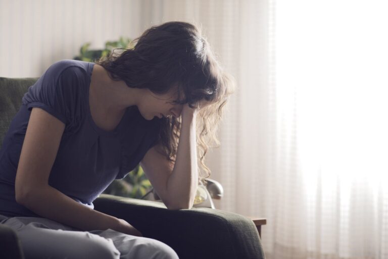 sad woman sitting alone by the window