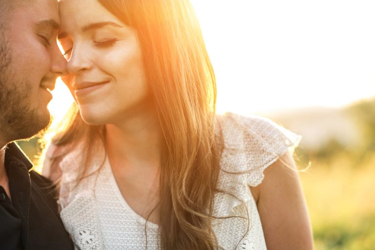 um casal amoroso abraça-se e beija-se ao pôr do sol