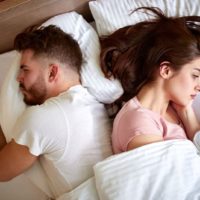 coppia triste sdraiata a letto