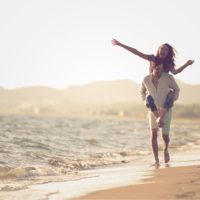 um casal apaixonado a divertir-se na praia