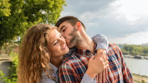 man kissing woman in the cheek