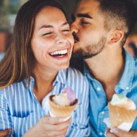 couple holding ice cream and kissing