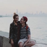 couple laughing and sitting beside sea