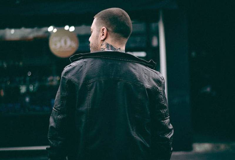back view of man wearing black jacket walking outside