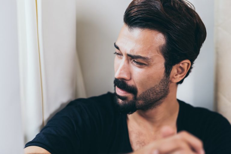 a portrait of a sad man with a beard