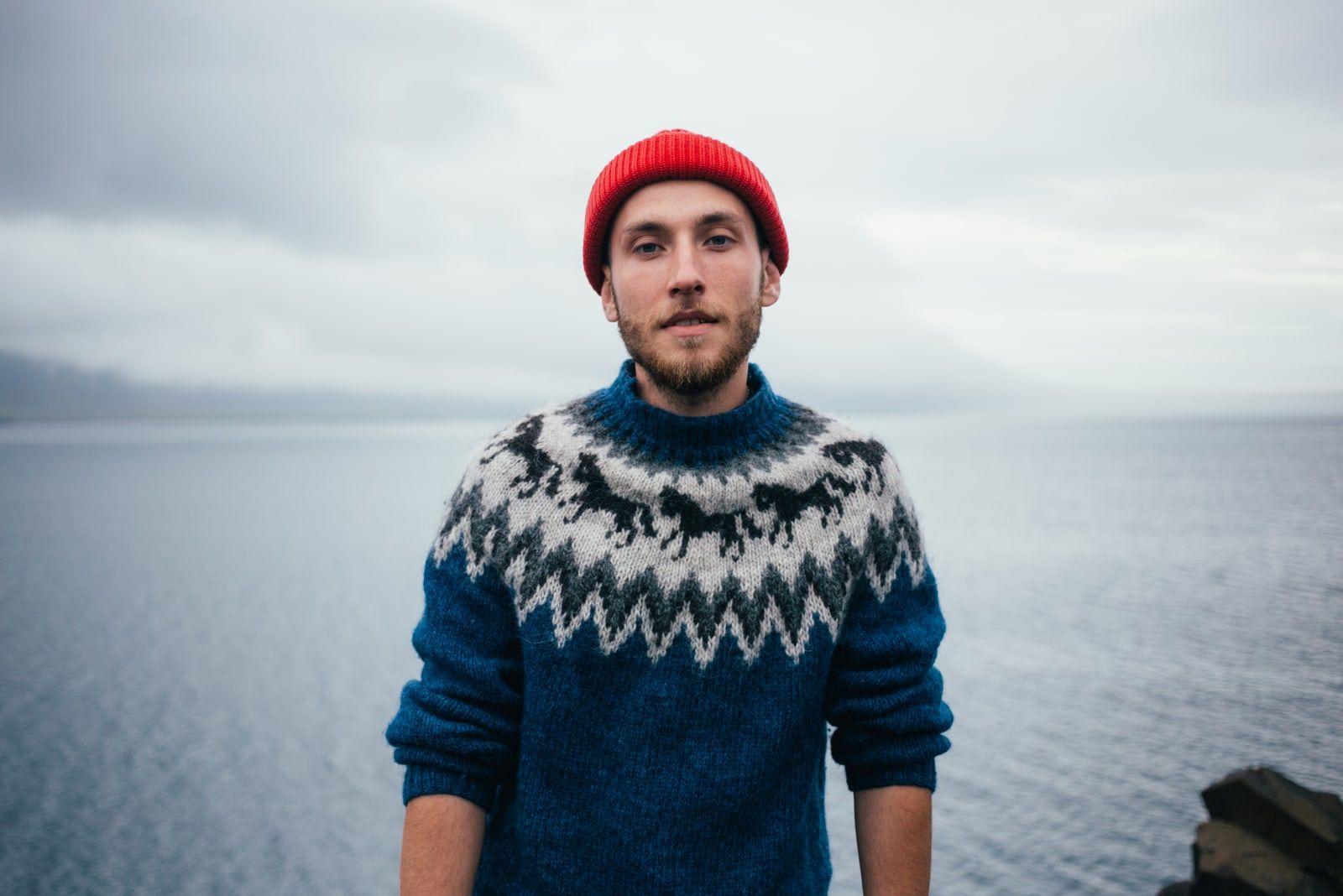 Young attractive bearded millennial man with red hat