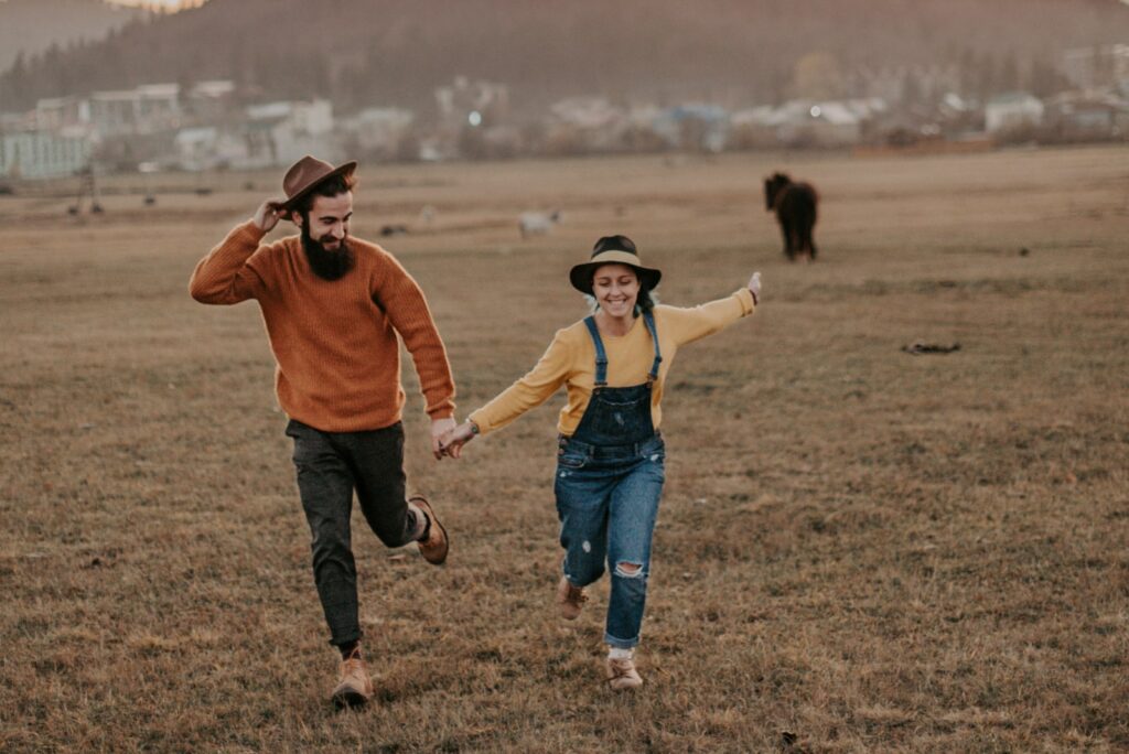 una chica corriendo por el campo con su novio