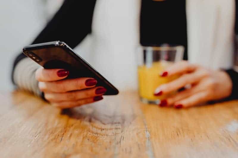 close up photo of woman holding a phone