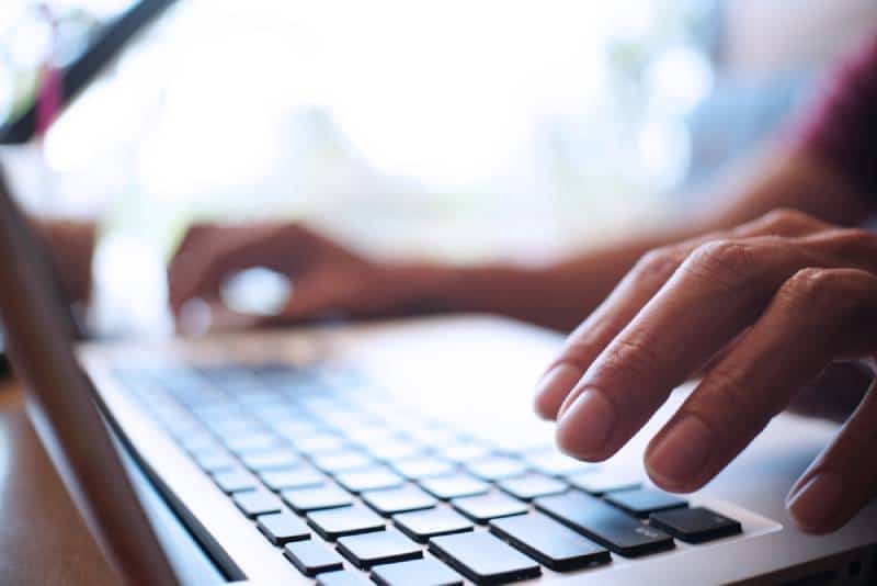 closeup photo of man working by using a laptop