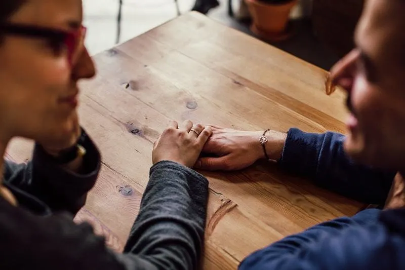 couple holding hands on the table