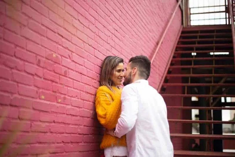 couple hugging and leaning on wall