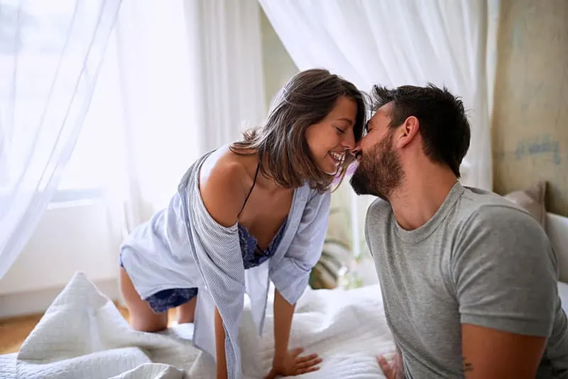 couple kissing on the bed