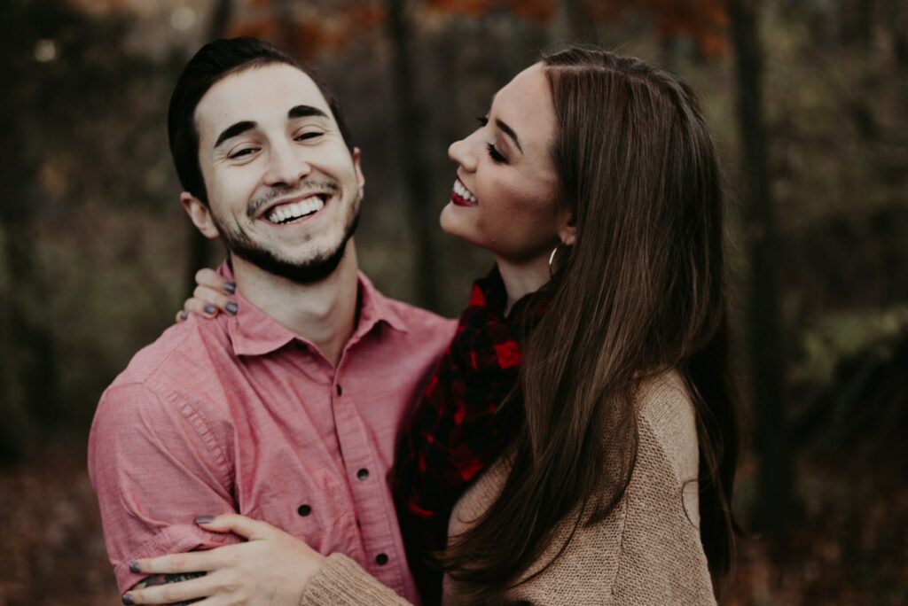 abrazando a una pareja sonriente en el bosque