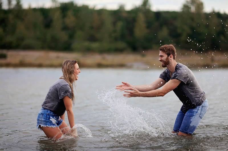 pareja feliz jugando en el agua