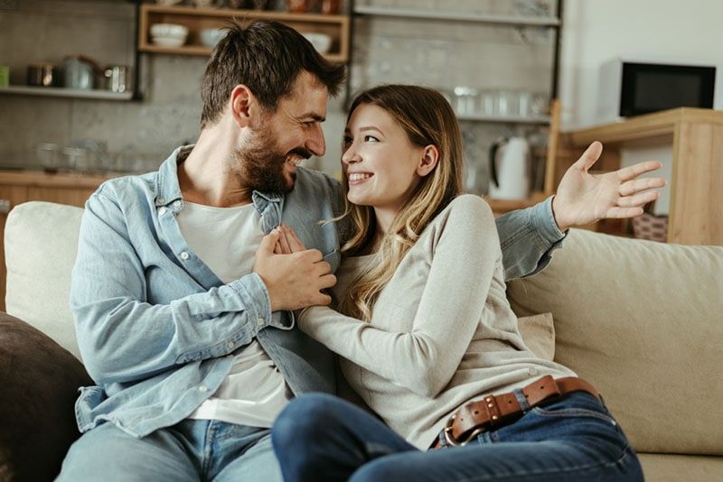 casal feliz sentado no sofá