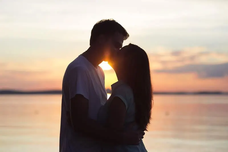 loving couple kissing at sunset