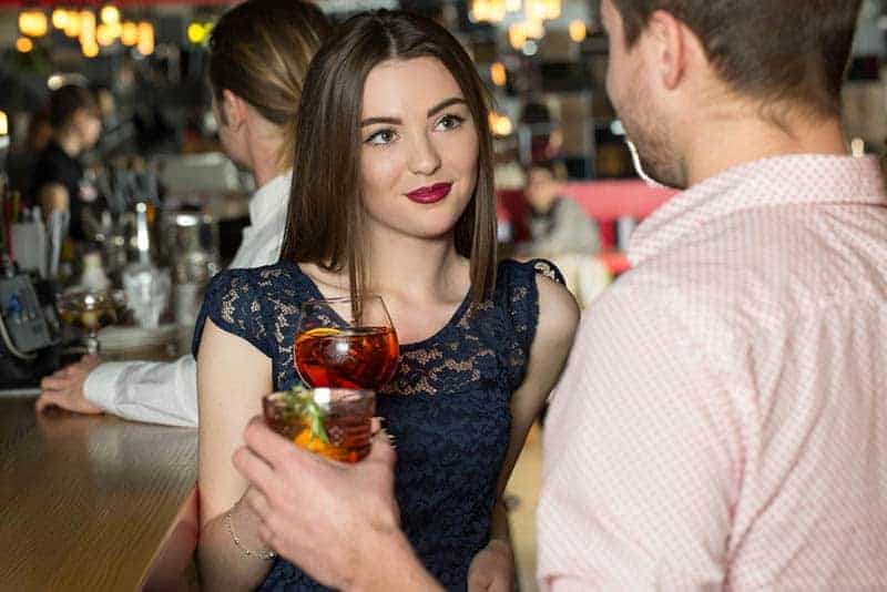 man and woman looking each other in bar