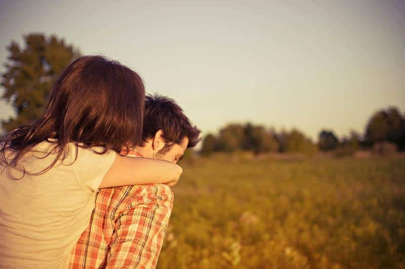 man carrying woman on his back