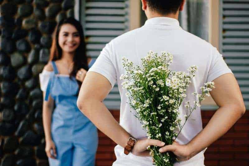 man holding flowers for his girlfriend