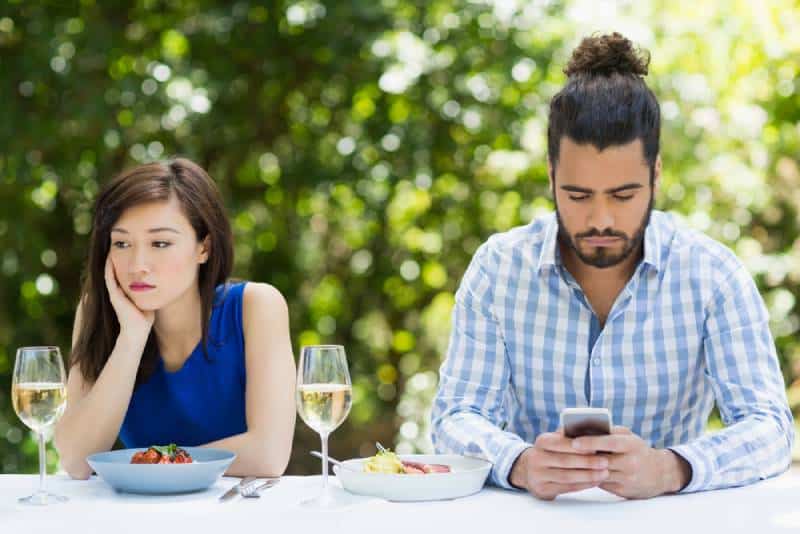 uomo che ignora la sua ragazza e usa il telefono