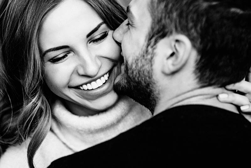 man kissing woman on cheek