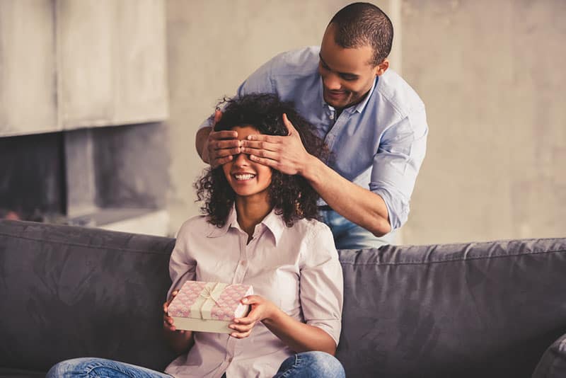 man surprising a woman with gift