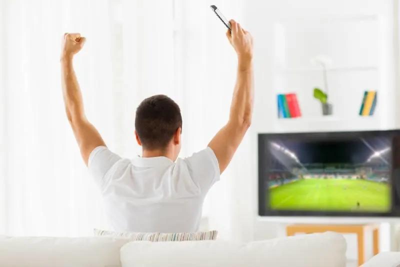 man watching football game on tv
