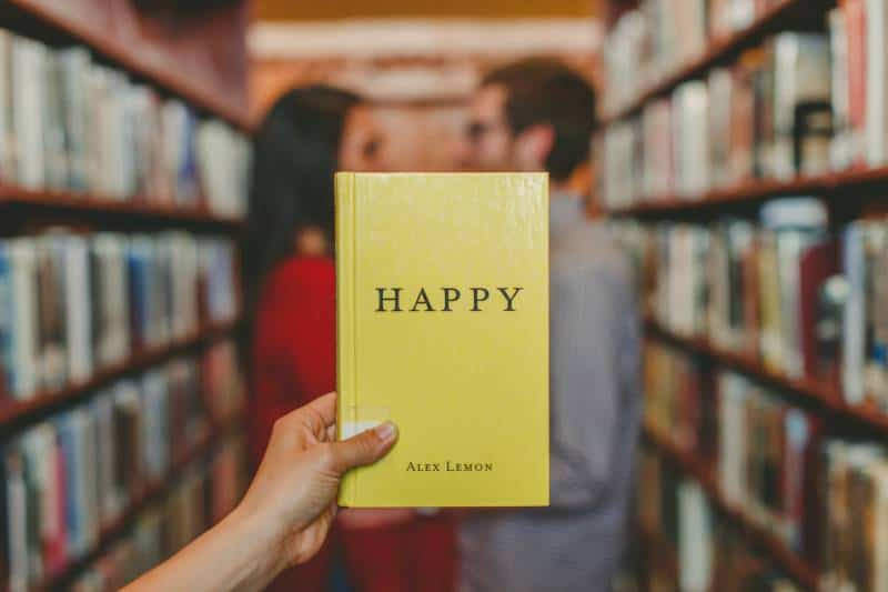 persona che tiene in mano il libro Happy di Alex Lemon