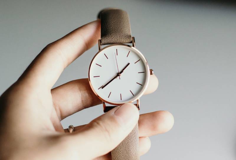 person holding analog watch