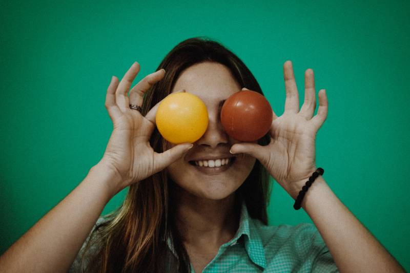person holding yellow and red ball toys