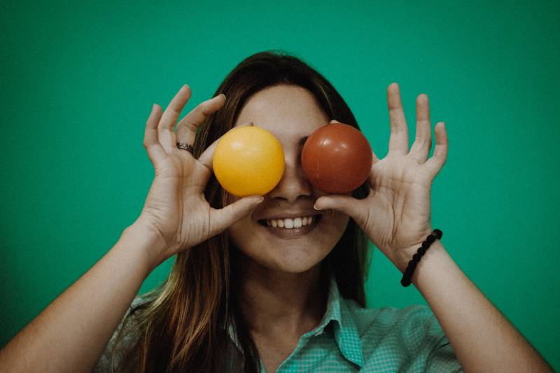 pessoa a segurar brinquedos com bolas amarelas e vermelhas