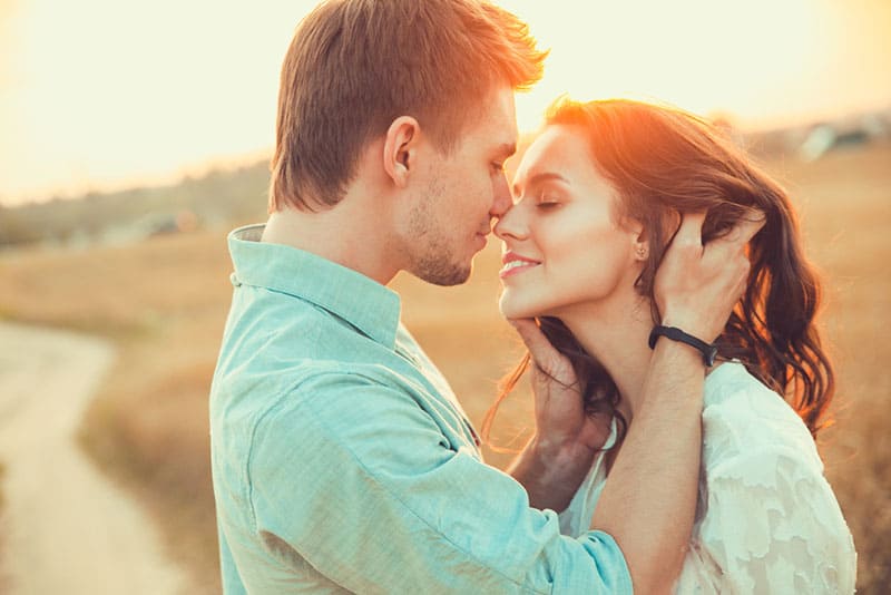 pareja romántica besándose al atardecer