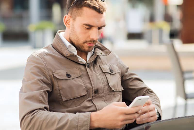 serious man sitting and texting