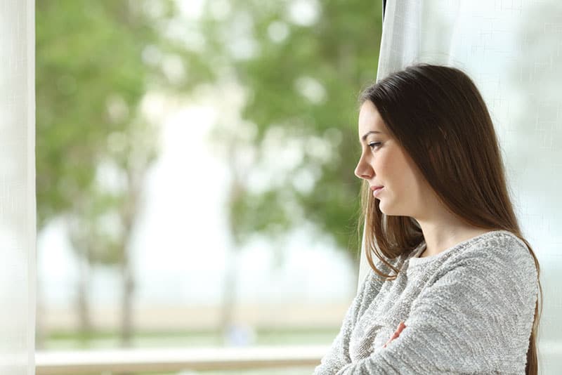 mujer seria junto a la ventana