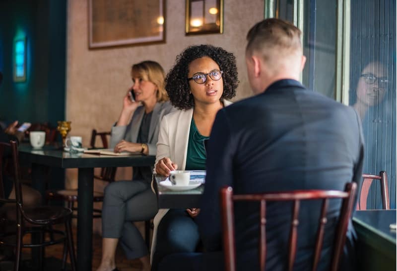 donna seria che parla con un uomo in un caffè