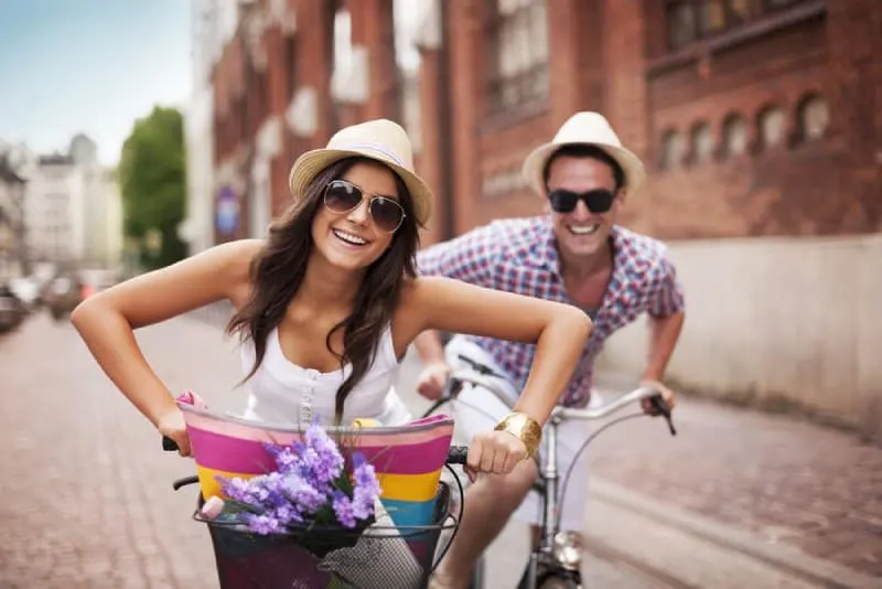 smiling couple cycling on the street