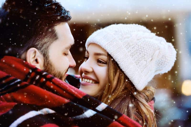 smiling couple looking at each other on winter