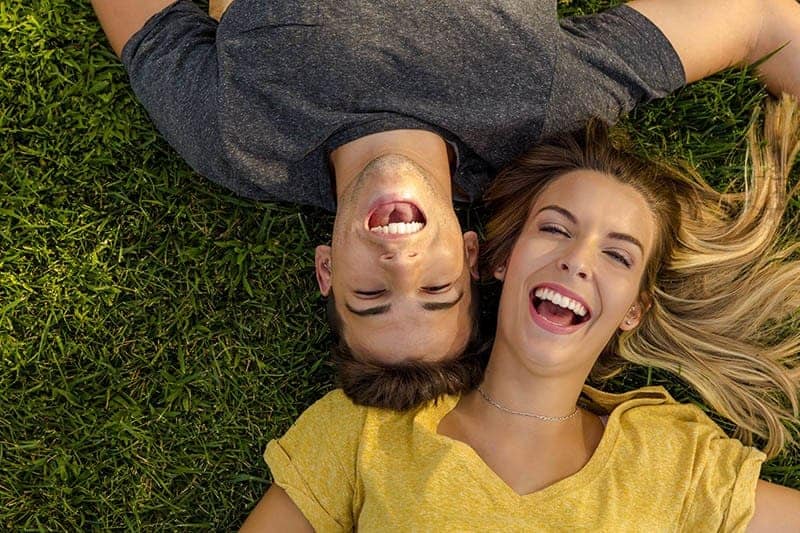 smiling couple lying together on the grass