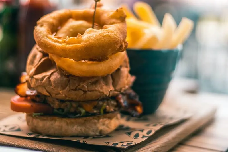 tasty burger with onion rings served on plate