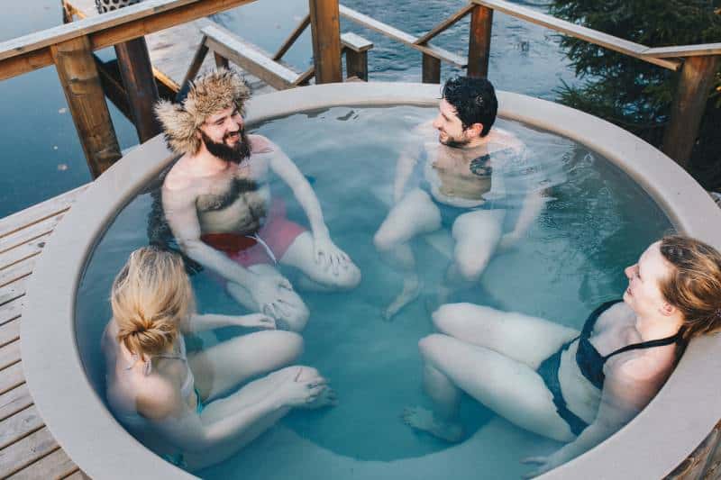 due maschi e due femmine seduti in una piscina arrotondata