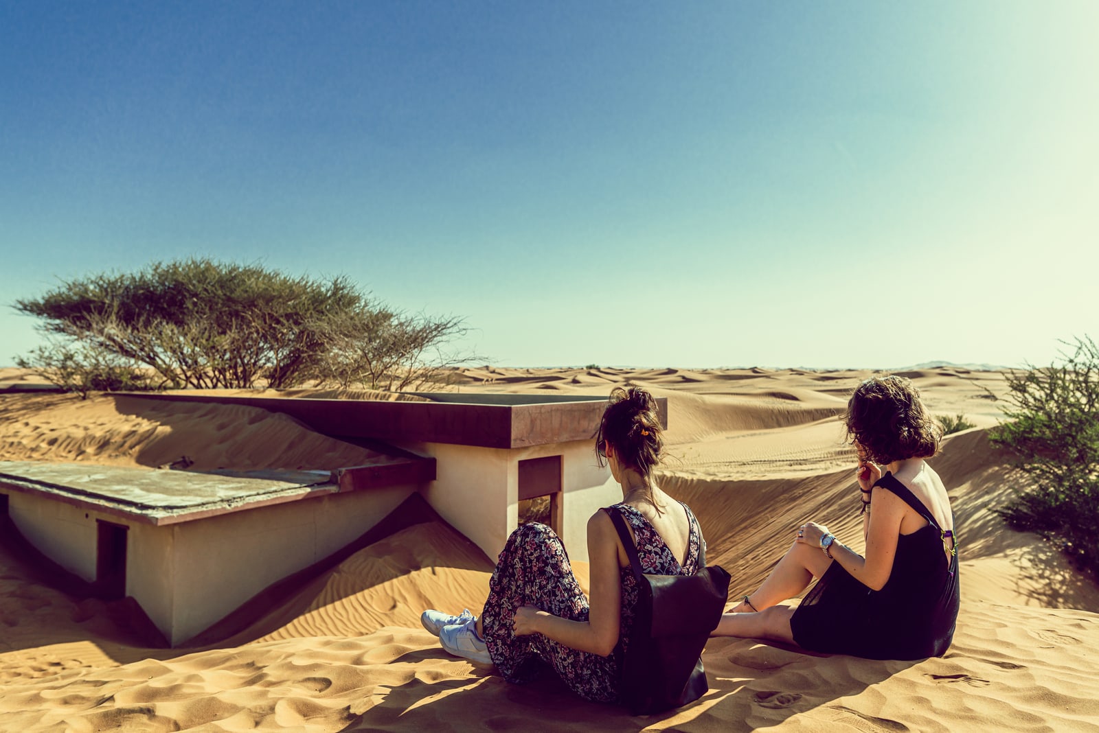 two women friends sitting in desert