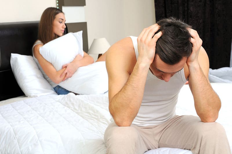 unhappy couple sitting on the bed