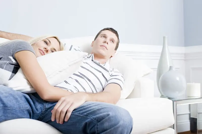 unintrested man laying in hug with woman