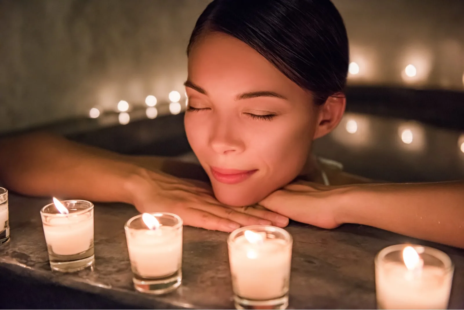 woman enjoying the bath with candles