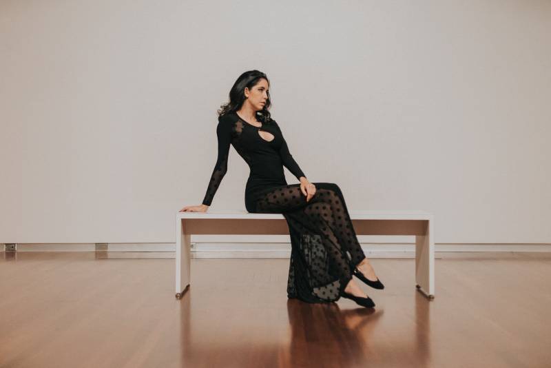 woman in black dress sitting on bench