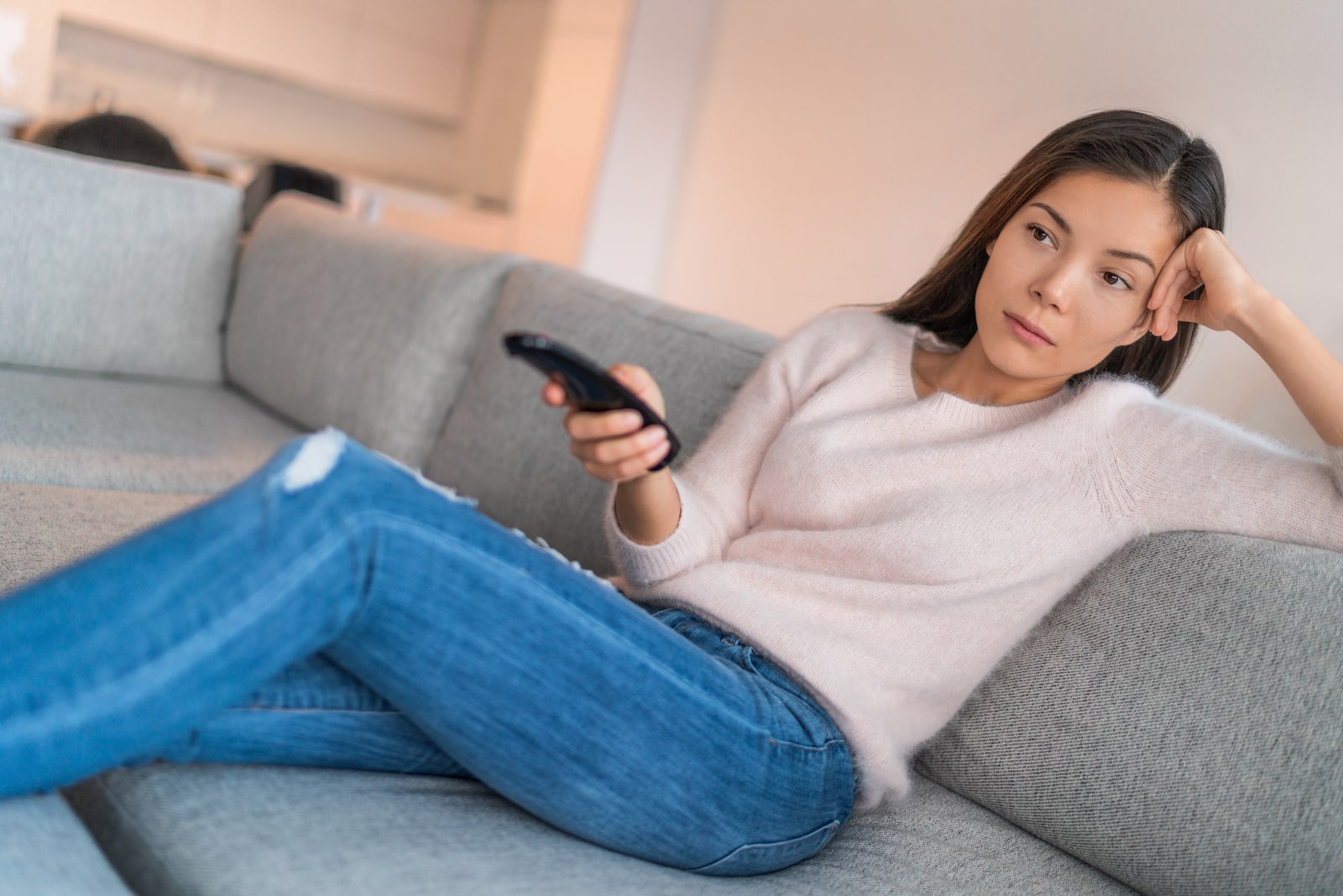 woman watching tv alone in apartment sitting on sofa