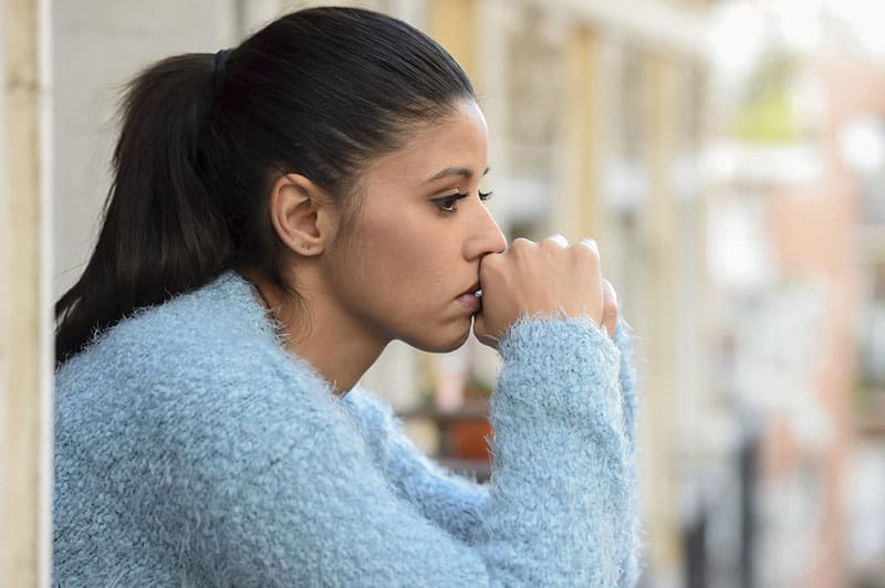 worried woman in blue sweather looking away